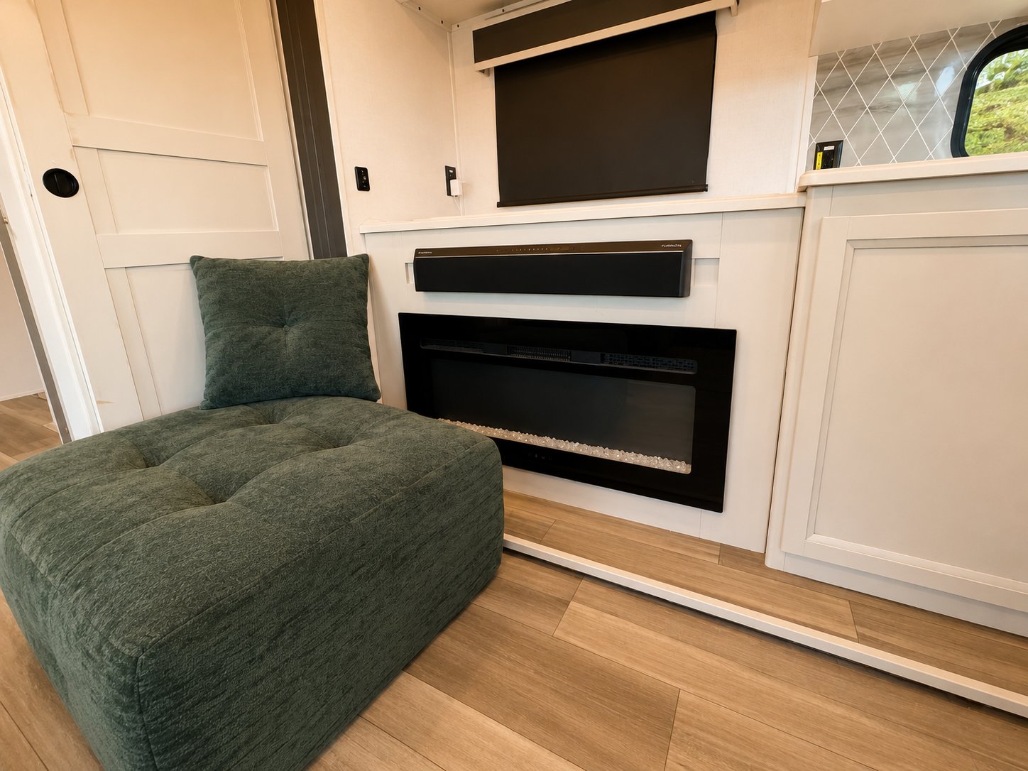 Cozy seating beside the indoor fireplace with a hidden pull-down TV screen above