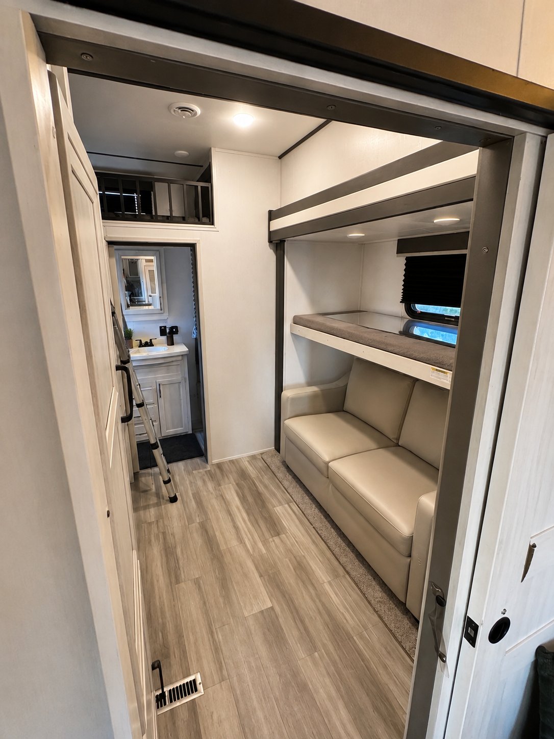 Second bedroom with sofa seating and loft bed above